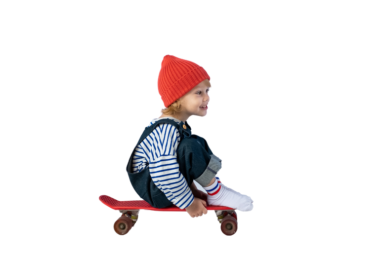 Child in Black and White Striped Long Sleeve Shirt and Red Knit Cap Sitting on Brown